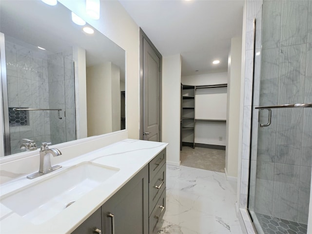 bathroom featuring a shower with shower door and vanity