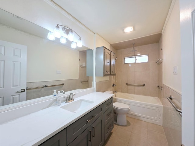 full bathroom with tile walls, tiled shower / bath combo, vanity, and tile patterned flooring