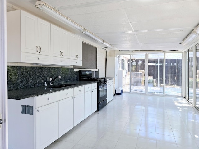 kitchen with sink, backsplash, white cabinets, and black range with gas cooktop