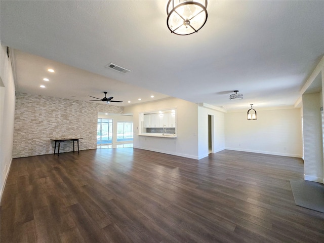 unfurnished living room with sink, ceiling fan, and dark hardwood / wood-style flooring