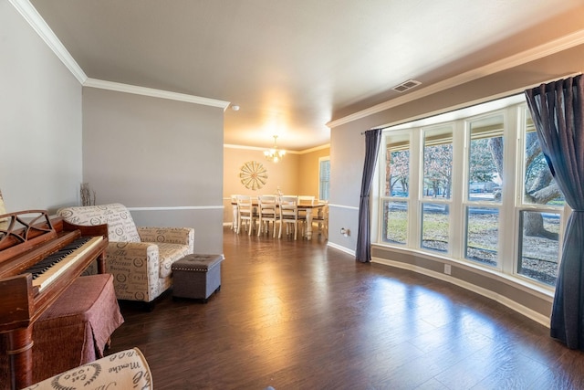 living area with a chandelier, ornamental molding, and dark hardwood / wood-style flooring