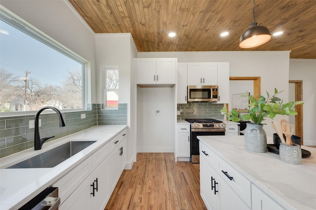 kitchen with sink, white cabinetry, wood ceiling, hanging light fixtures, and stainless steel appliances