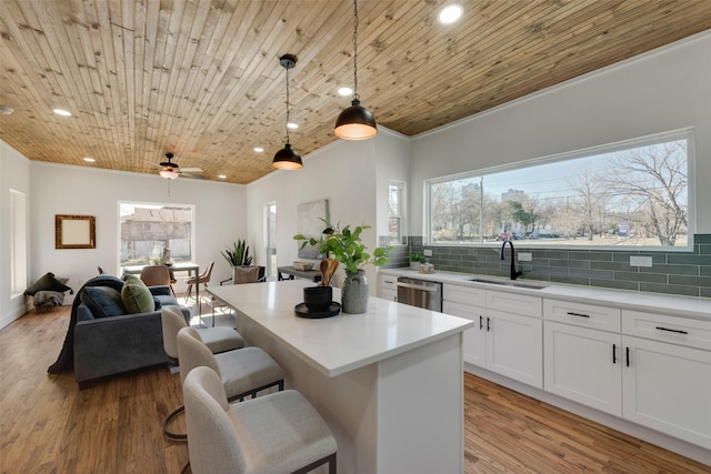 kitchen with sink, wood ceiling, white cabinetry, decorative light fixtures, and stainless steel dishwasher