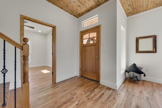 entrance foyer featuring ornamental molding, plenty of natural light, wooden ceiling, and light hardwood / wood-style flooring