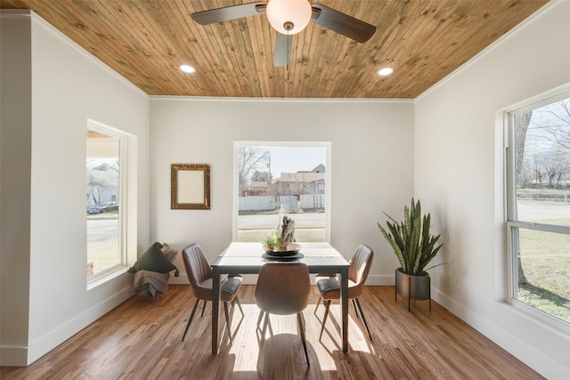 dining room featuring ornamental molding, light wood-type flooring, and wooden ceiling