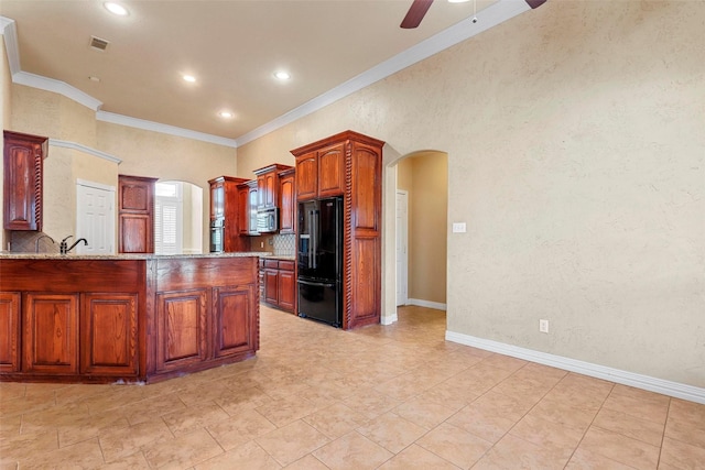 kitchen with kitchen peninsula, ceiling fan, decorative backsplash, ornamental molding, and black fridge