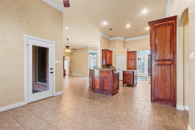 kitchen featuring crown molding, light tile patterned flooring, a center island, and ceiling fan