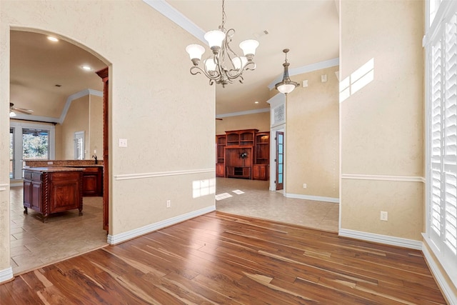 dining area featuring ceiling fan with notable chandelier, lofted ceiling, dark hardwood / wood-style flooring, and crown molding