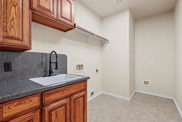 clothes washing area featuring sink, hookup for a washing machine, hookup for an electric dryer, and cabinets