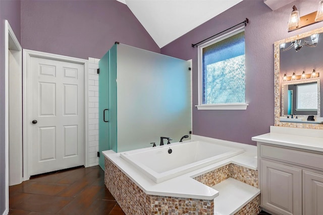 bathroom featuring vanity, vaulted ceiling, and independent shower and bath