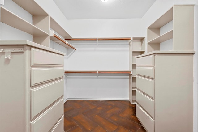 walk in closet with dark parquet floors