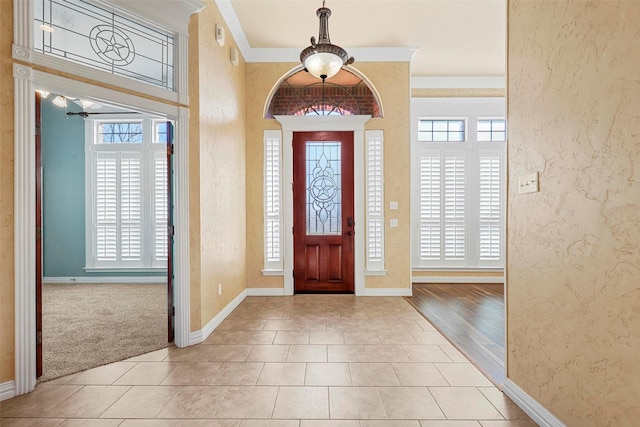 tiled foyer entrance featuring ornamental molding