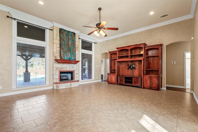 unfurnished living room featuring ceiling fan, a stone fireplace, and crown molding