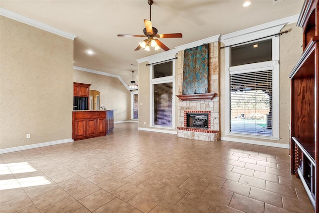 unfurnished living room with ceiling fan, ornamental molding, and a stone fireplace