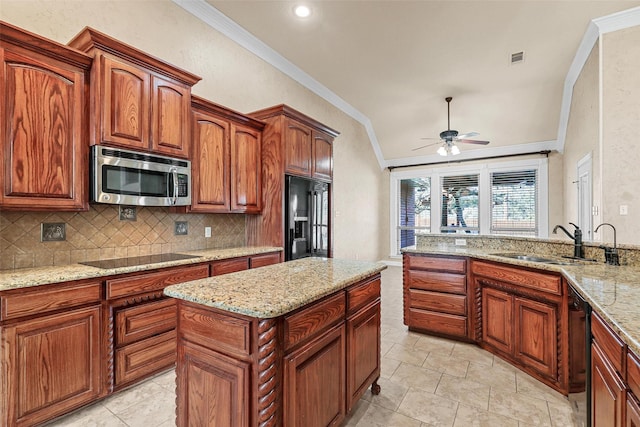 kitchen featuring light stone countertops, black appliances, decorative backsplash, sink, and ceiling fan