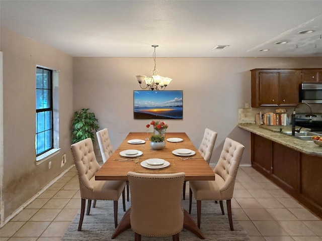 tiled dining space with a chandelier