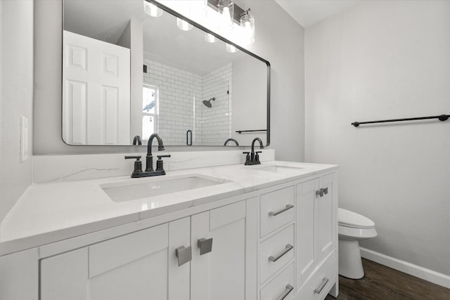 bathroom featuring a shower with shower door, hardwood / wood-style floors, toilet, and vanity