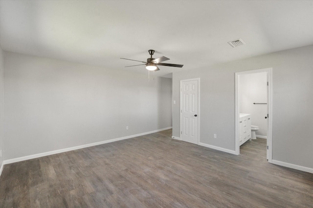 unfurnished bedroom with a closet, ceiling fan, connected bathroom, and dark wood-type flooring