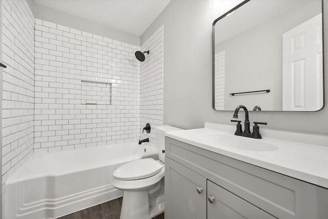 full bathroom with vanity, hardwood / wood-style flooring, tiled shower / bath, and toilet