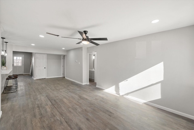 unfurnished living room featuring ceiling fan and dark hardwood / wood-style flooring