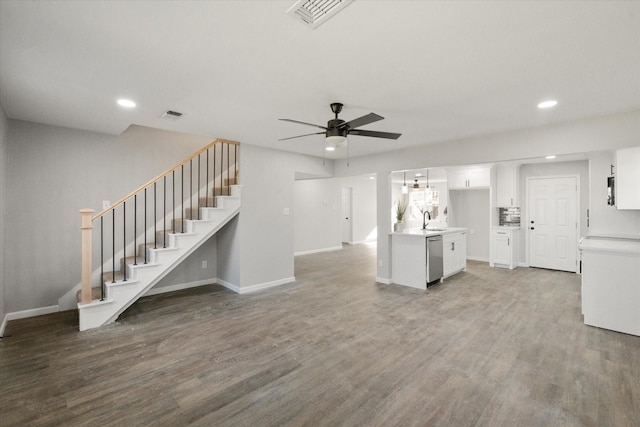 unfurnished living room featuring sink, hardwood / wood-style flooring, and ceiling fan