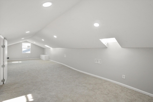 bonus room with light colored carpet and lofted ceiling