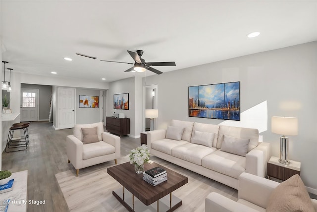 living room featuring ceiling fan and light hardwood / wood-style flooring