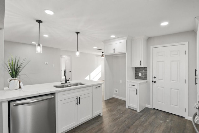 kitchen with light stone countertops, pendant lighting, white cabinets, sink, and stainless steel dishwasher