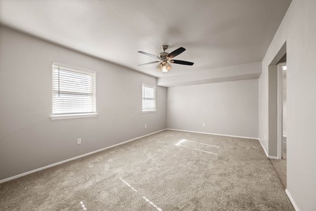 spare room with ceiling fan and light colored carpet