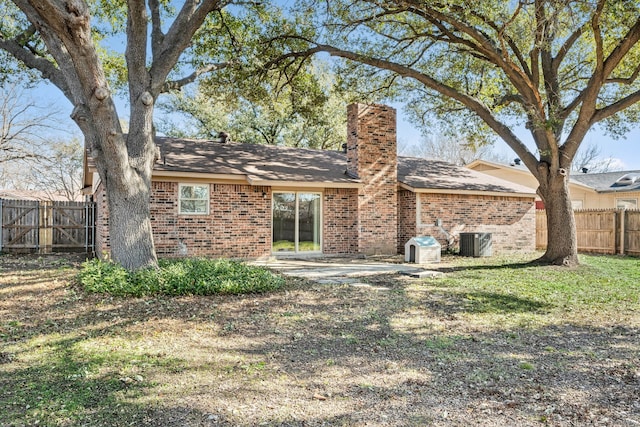 back of property featuring a lawn, central air condition unit, and a patio