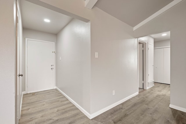 hallway featuring lofted ceiling and light wood-type flooring