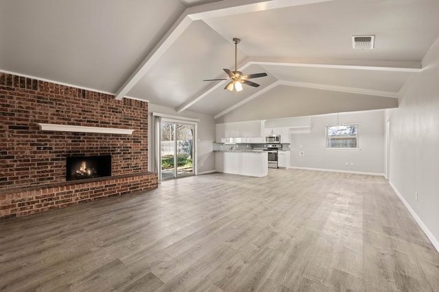 unfurnished living room featuring a fireplace, light wood-type flooring, vaulted ceiling with beams, and ceiling fan