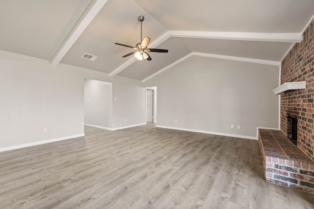 unfurnished living room featuring a fireplace, light hardwood / wood-style floors, vaulted ceiling, and ceiling fan