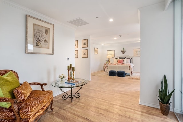 sitting room featuring ornamental molding and light hardwood / wood-style flooring