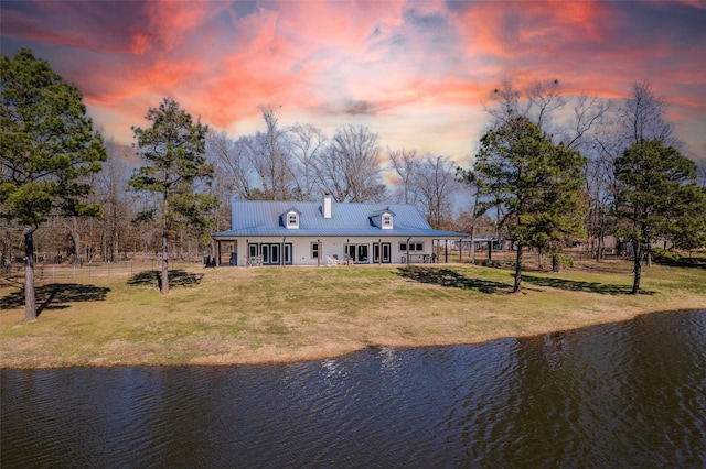 back house at dusk featuring a water view