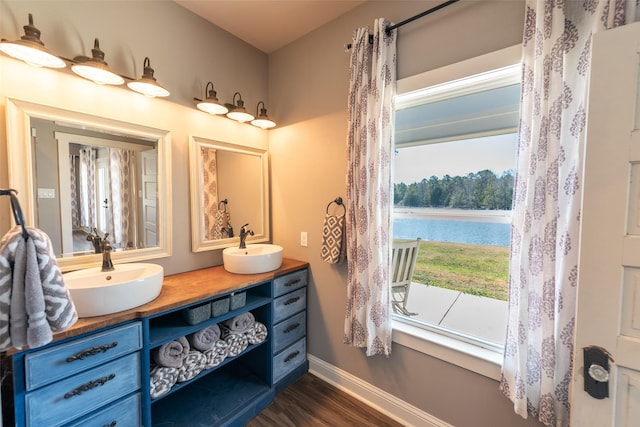 bathroom with hardwood / wood-style flooring, a water view, and vanity