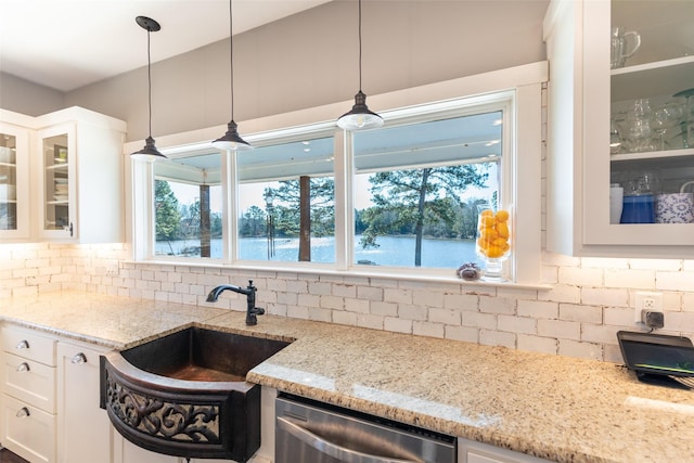 kitchen with white cabinetry, a water view, sink, stainless steel dishwasher, and tasteful backsplash