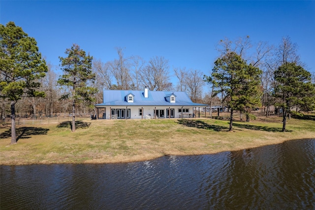 rear view of house featuring a yard and a water view