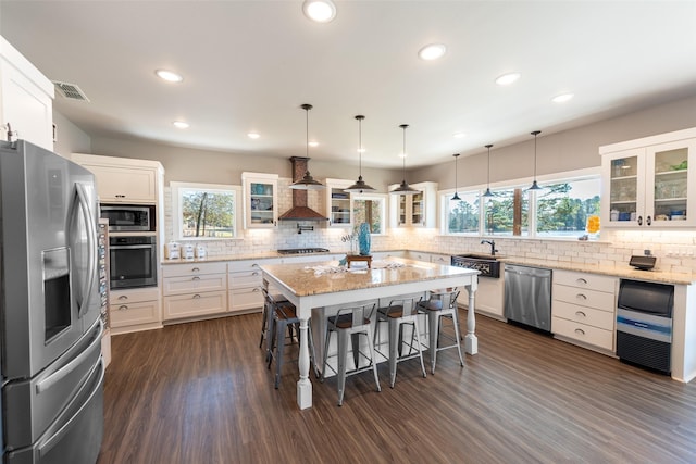 kitchen featuring white cabinets, a center island, appliances with stainless steel finishes, and a breakfast bar area