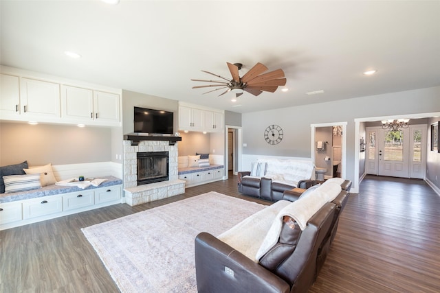 living room featuring a fireplace, ceiling fan, and dark hardwood / wood-style floors