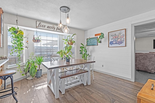 dining room featuring hardwood / wood-style flooring and a textured ceiling