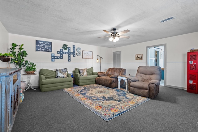 carpeted living room with ceiling fan and a textured ceiling