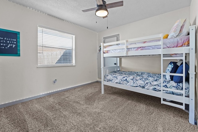 bedroom with ceiling fan, carpet, and a textured ceiling