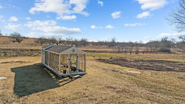 view of yard featuring an outdoor structure and a rural view