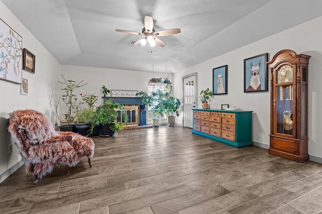 sitting room with hardwood / wood-style floors, a fireplace, and ceiling fan