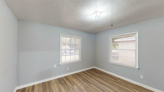 spare room featuring hardwood / wood-style flooring and a textured ceiling