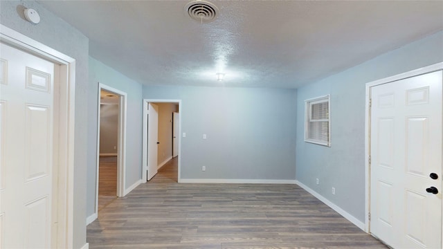 interior space with dark wood-type flooring and a textured ceiling