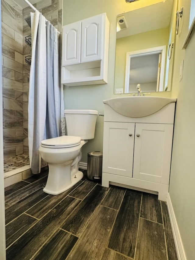 bathroom featuring vanity, toilet, and walk in shower