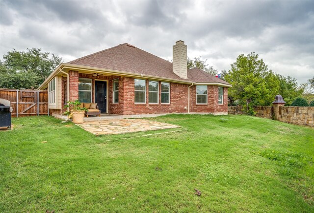 rear view of house with a patio area and a lawn