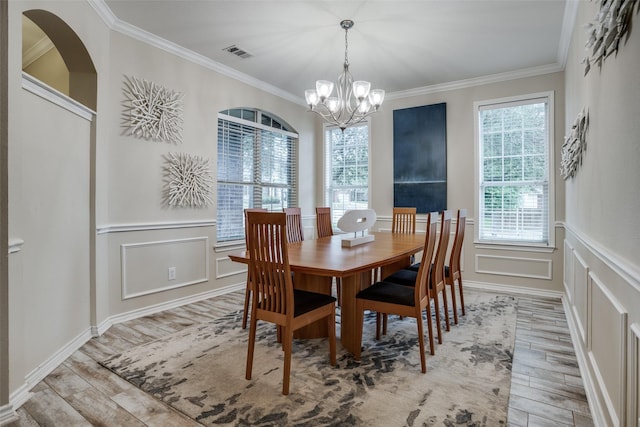 dining space with crown molding and a chandelier